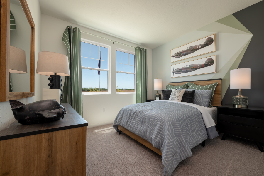 A bedroom with a bed and lamps.