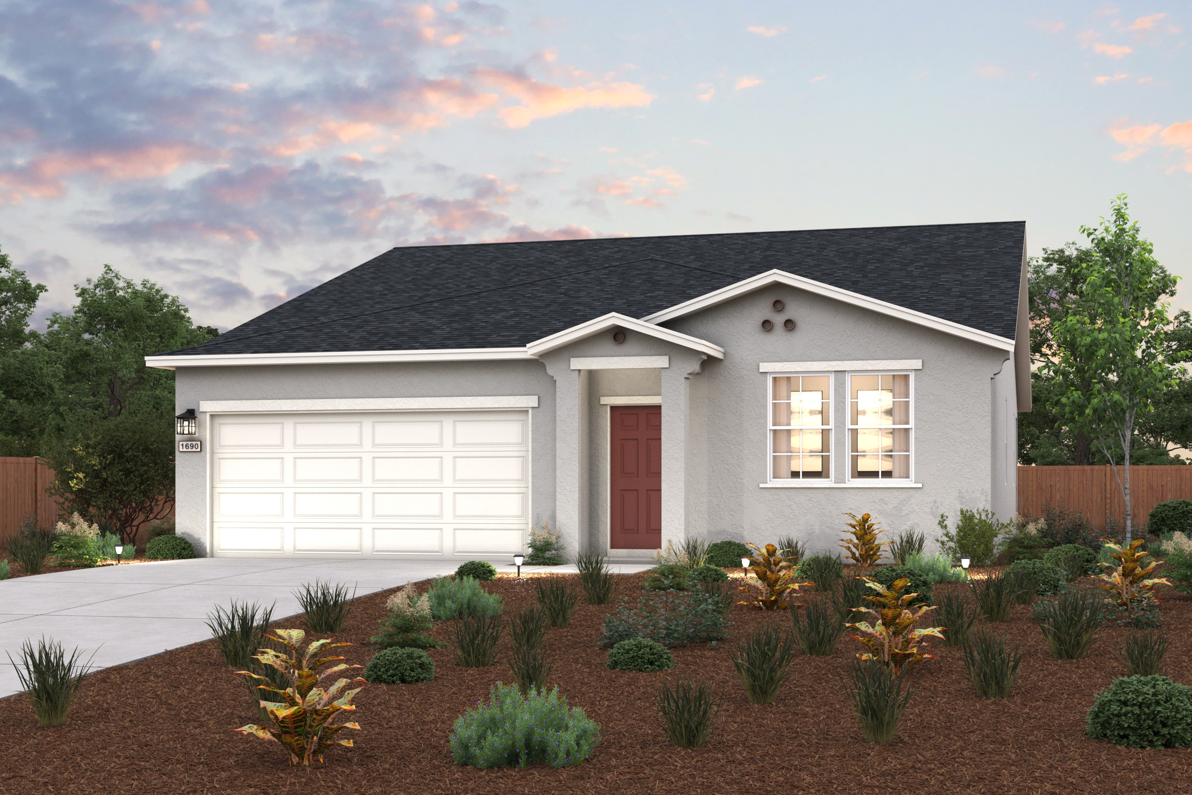 A house with a garage and bushes in front of it.