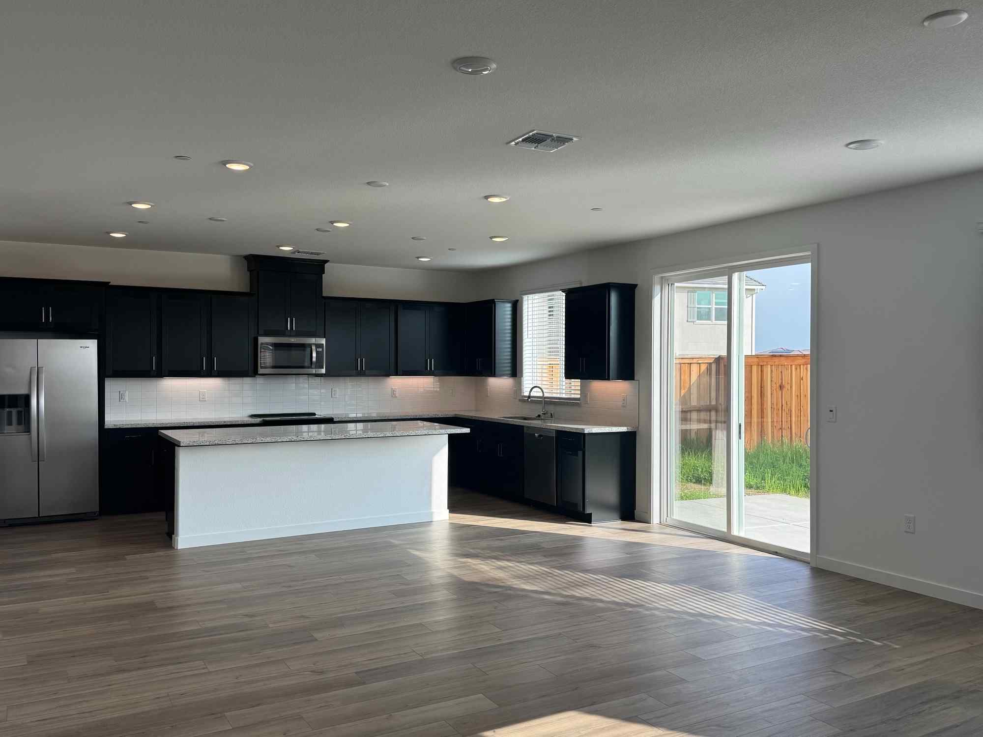 A large kitchen with black cabinets.