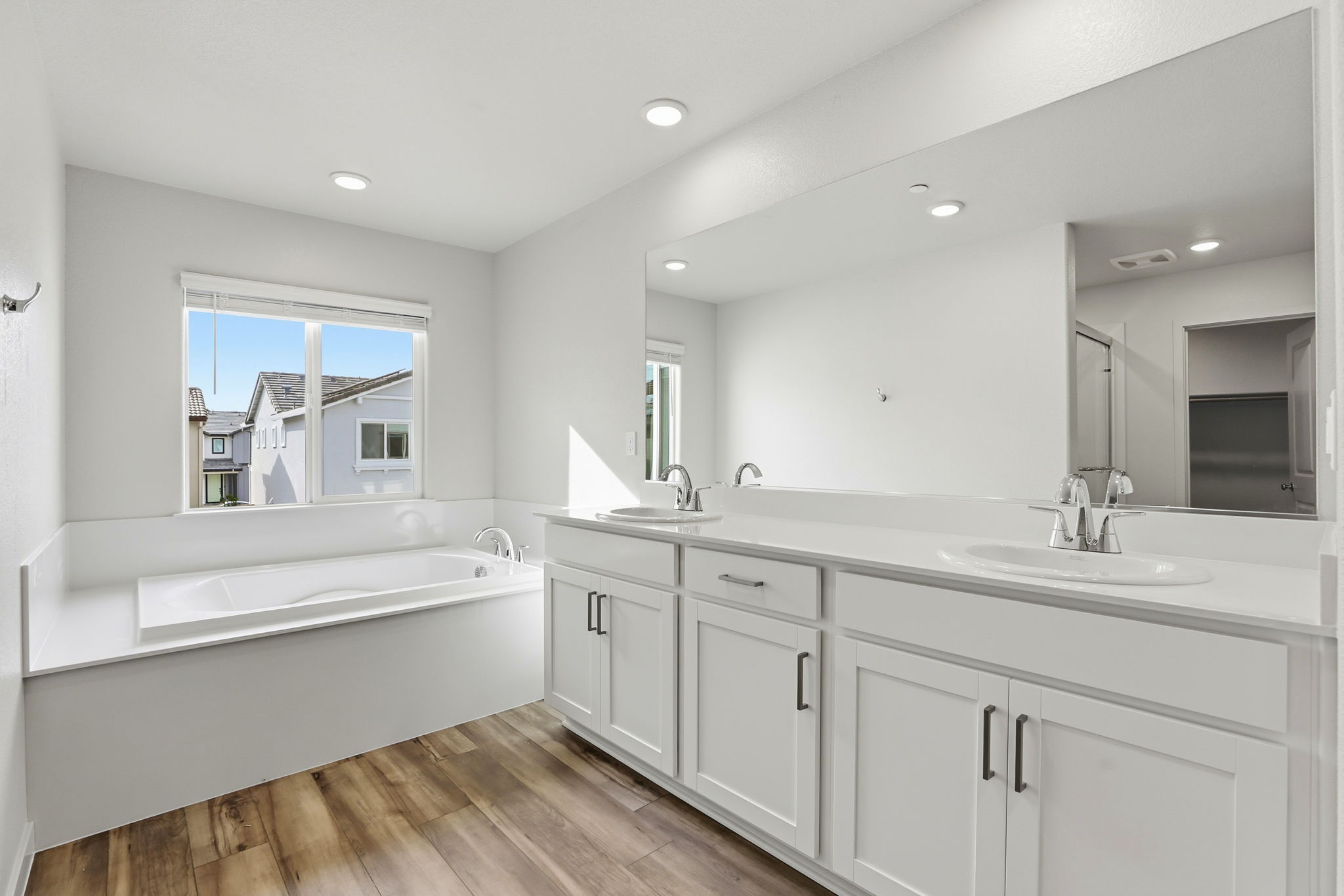 A bathroom with a tub sink and a mirror.