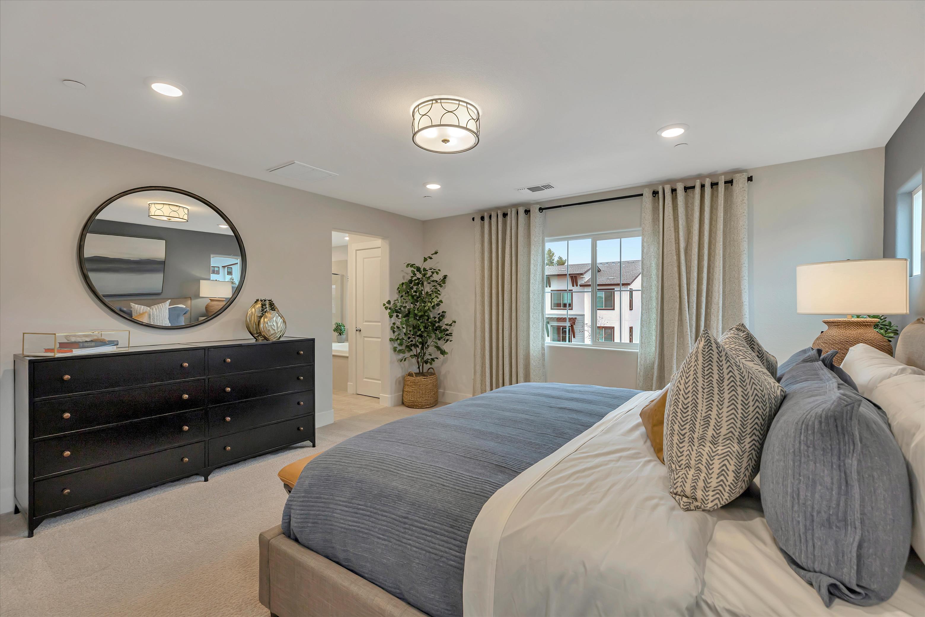 A bedroom with a large mirror.