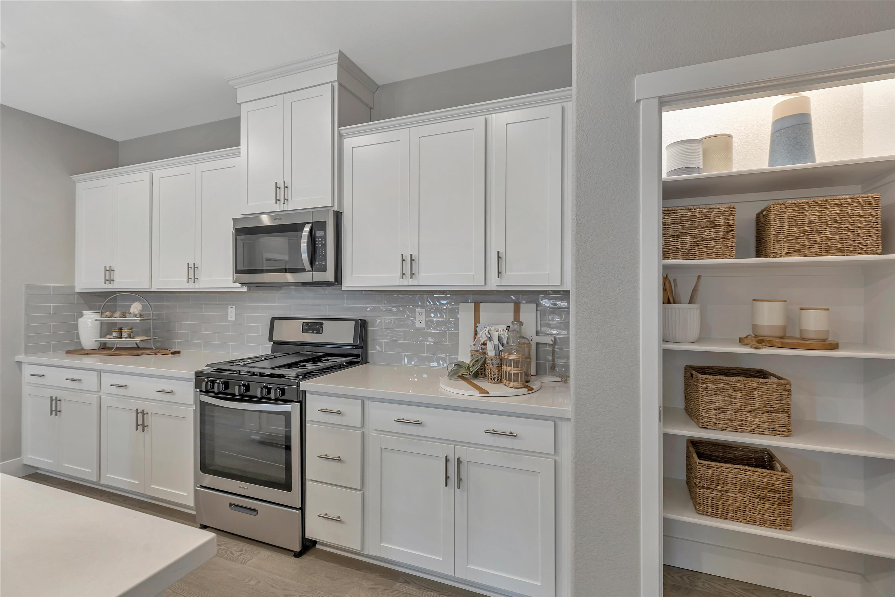 A kitchen with white cabinets.