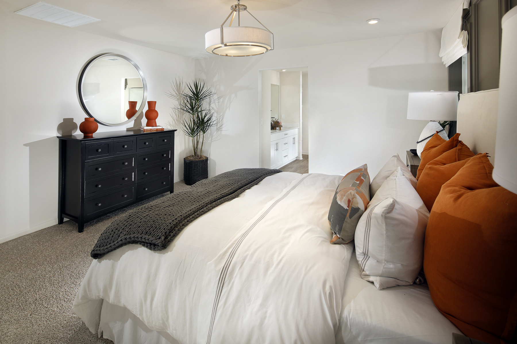 A bedroom with a bed and a mirror.