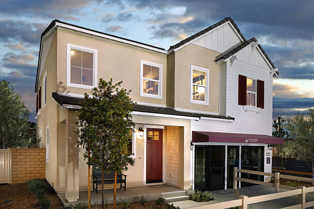 A white building with a tree in front of it.