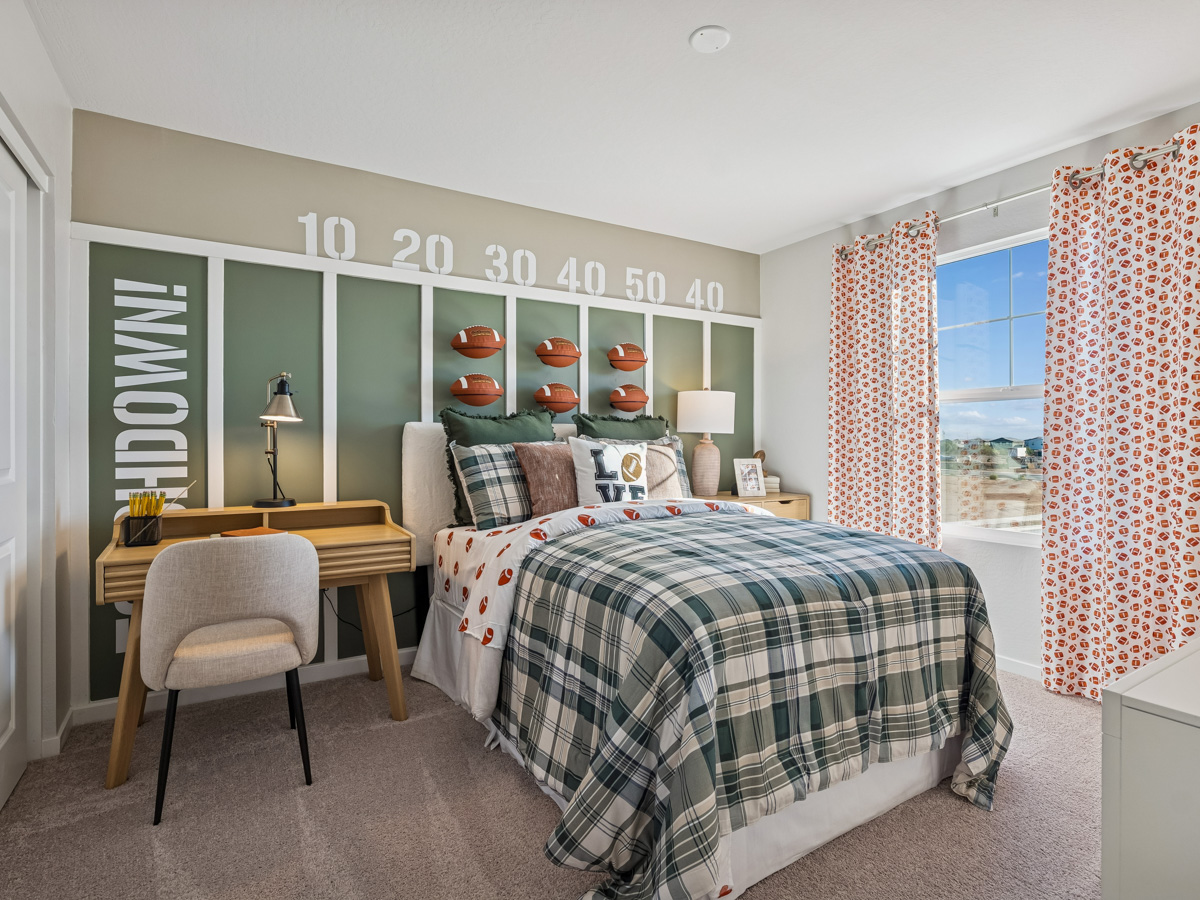 A bedroom with a bed and a desk.