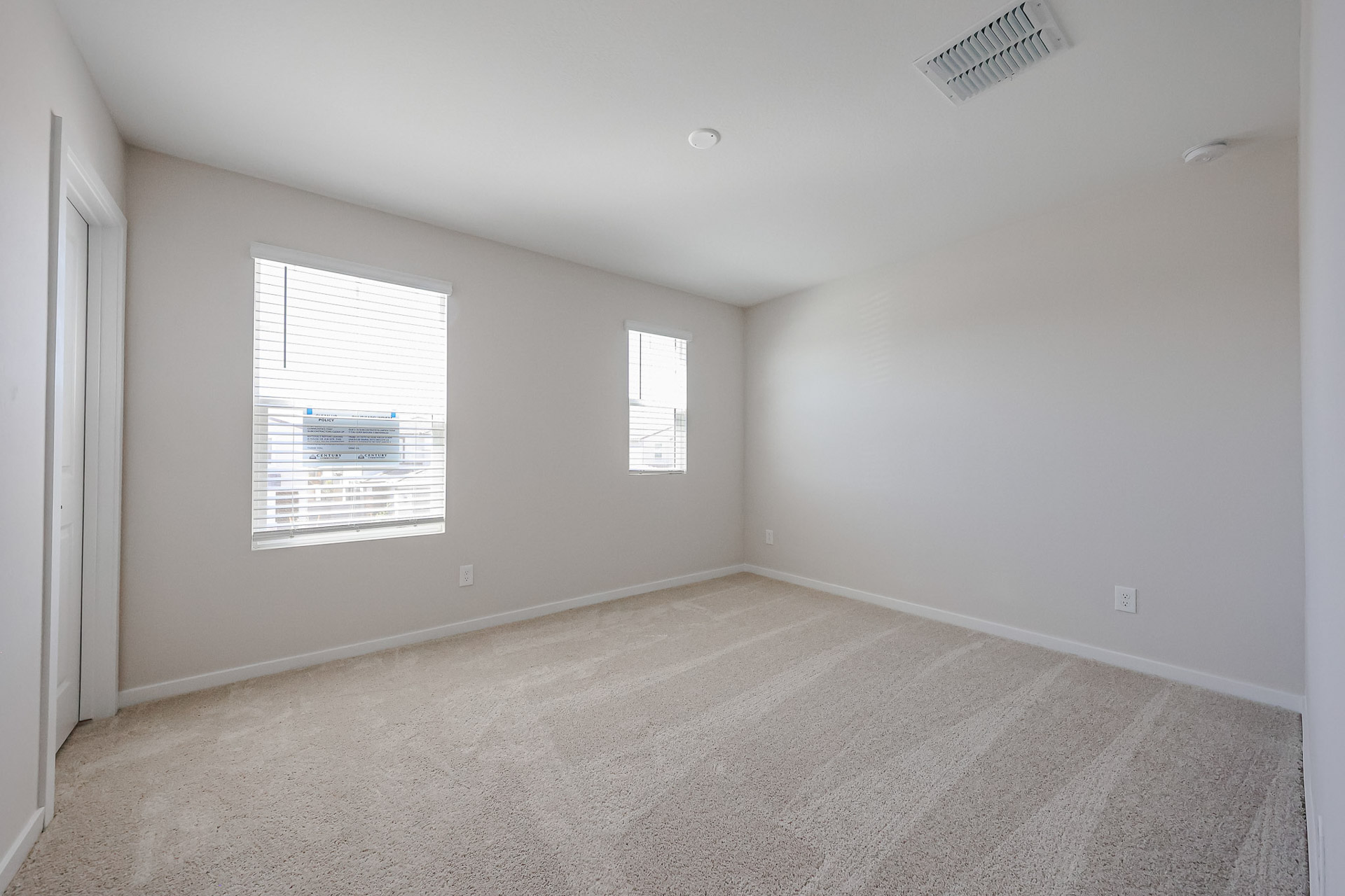 A room with a carpet and windows.