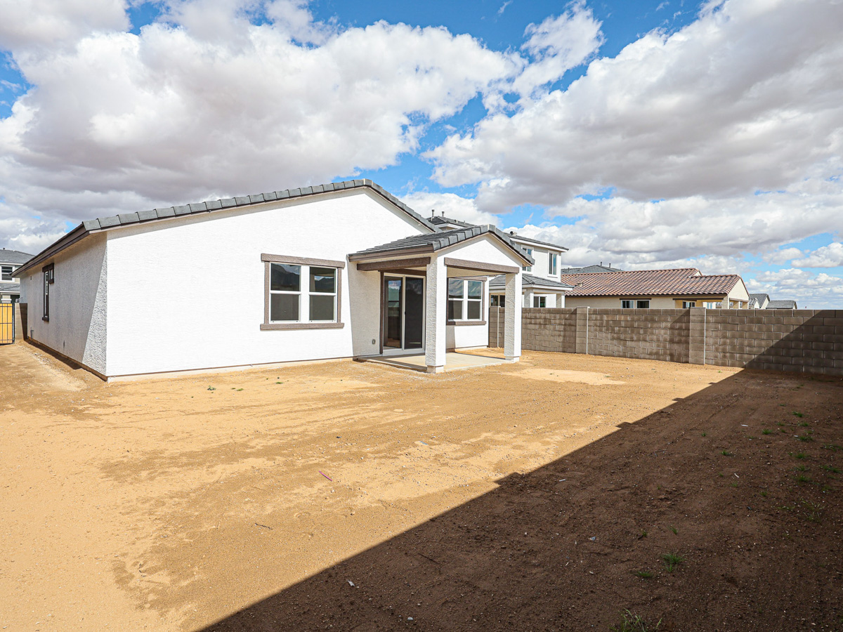 A white house with a dirt yard.