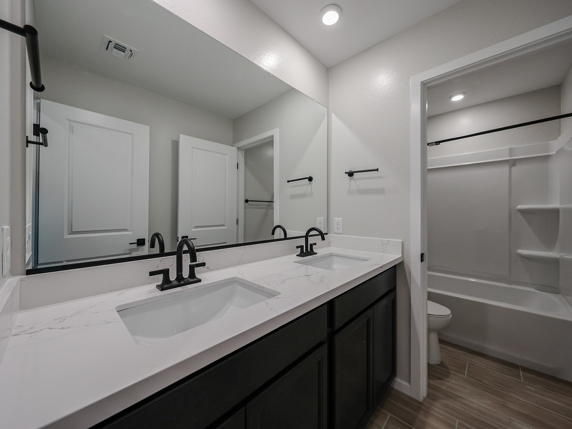 A bathroom with a tub sink and toilet.