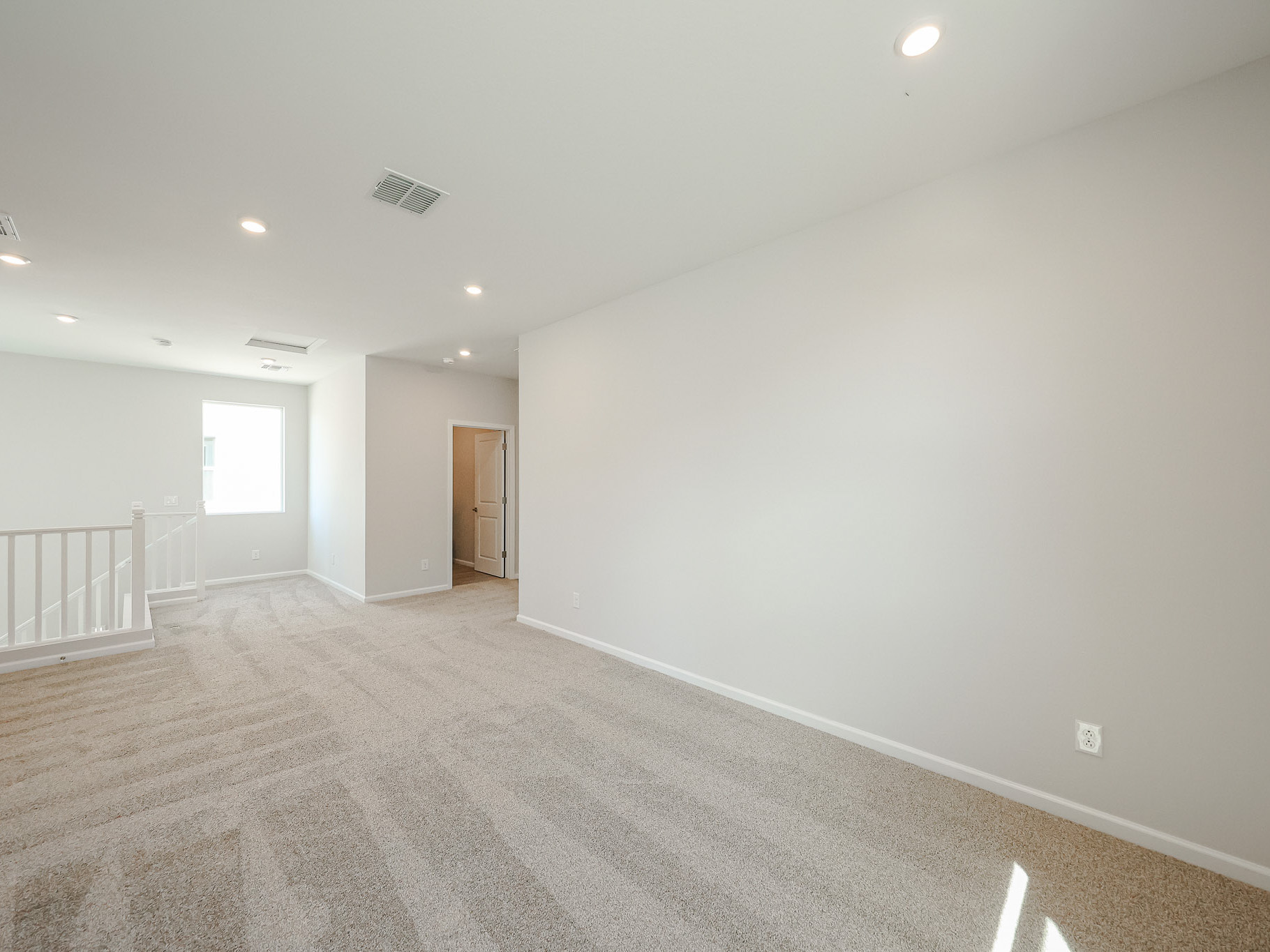 A room with a carpet and a door.