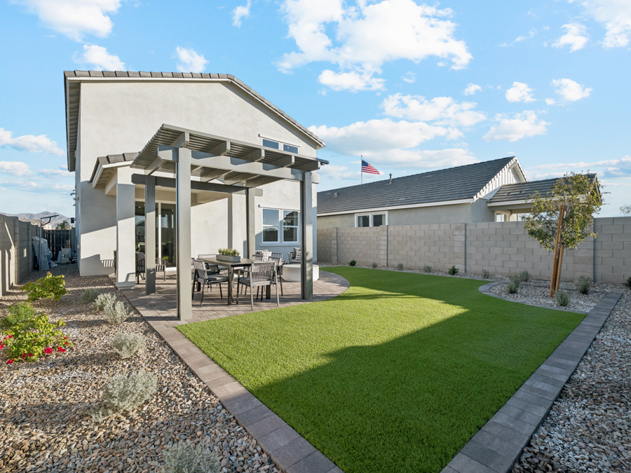 A building with a lawn and a table and chairs in front.