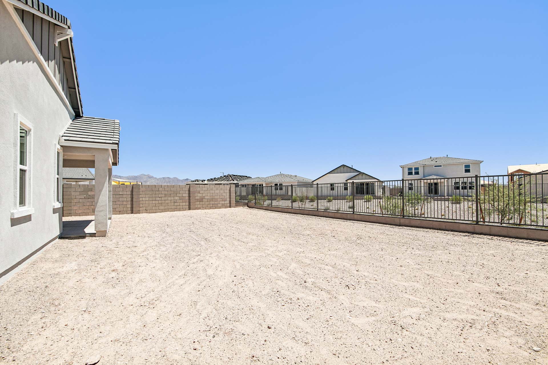 A sandy area with buildings in the background.