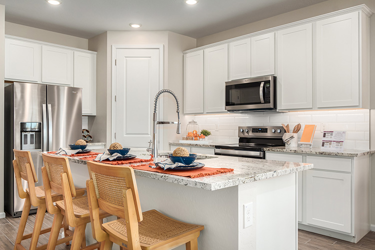 A kitchen with white cabinets.