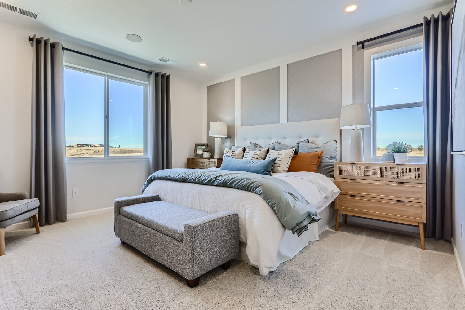 A bedroom with a bed and a chair.