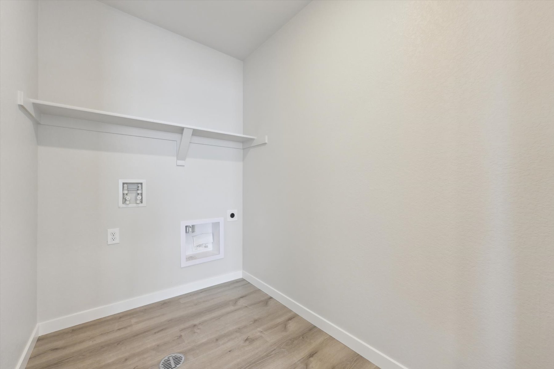 A white room with a wood floor.