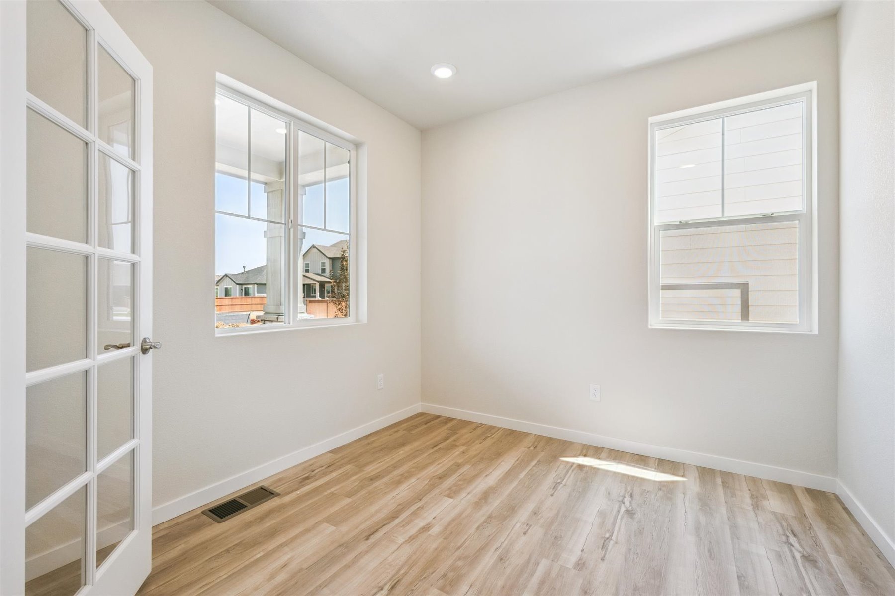 A room with a wood floor and white walls.