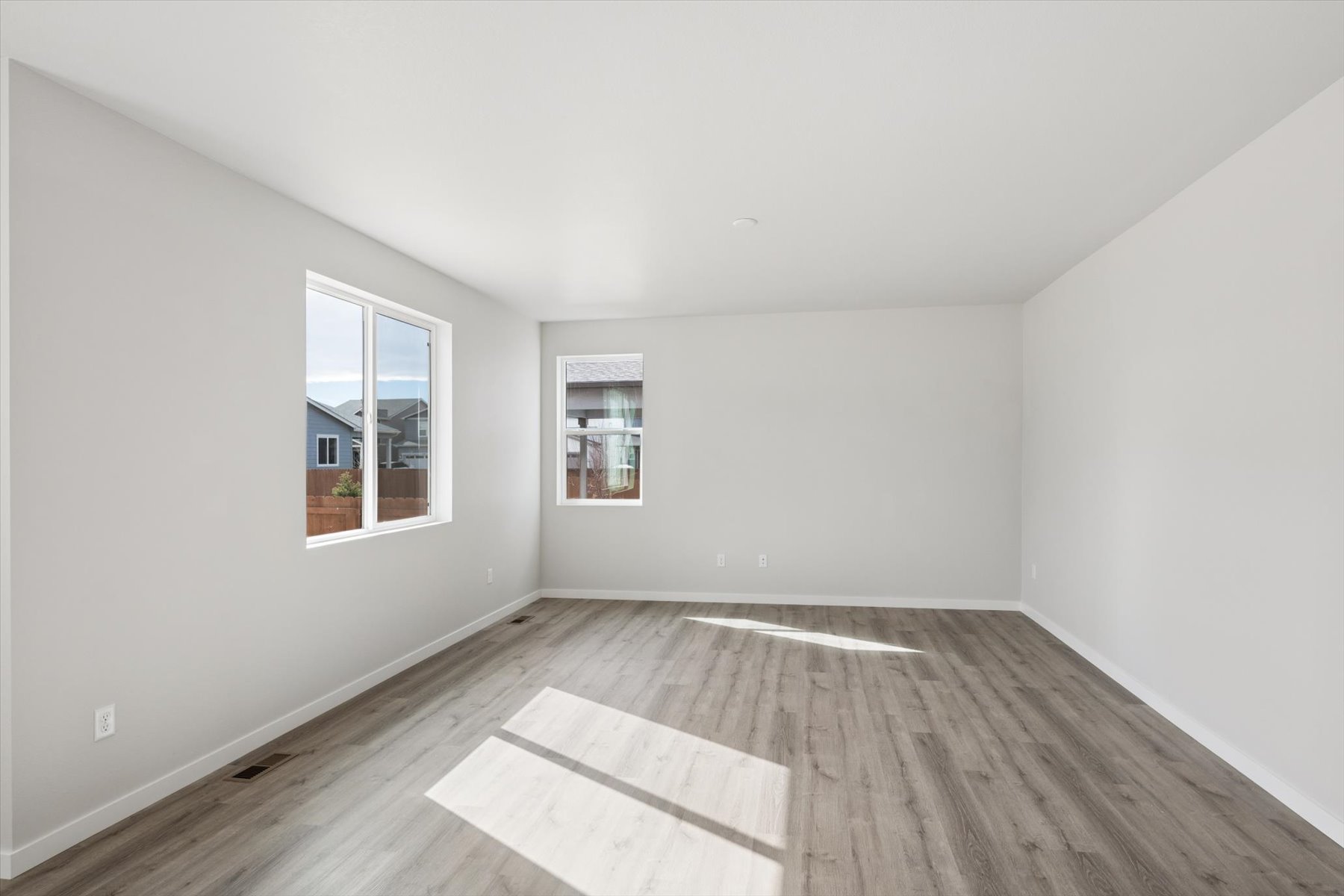 A room with a wood floor and windows.