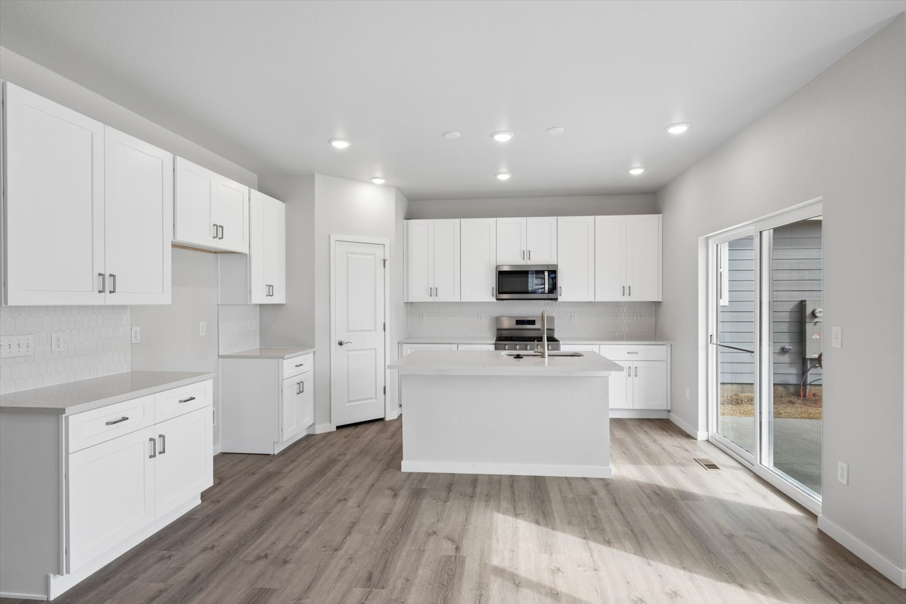 A kitchen with white cabinets.