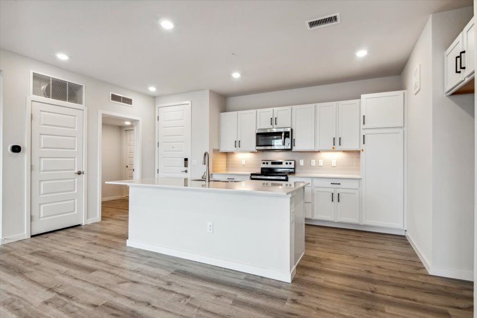 A kitchen with white cabinets.