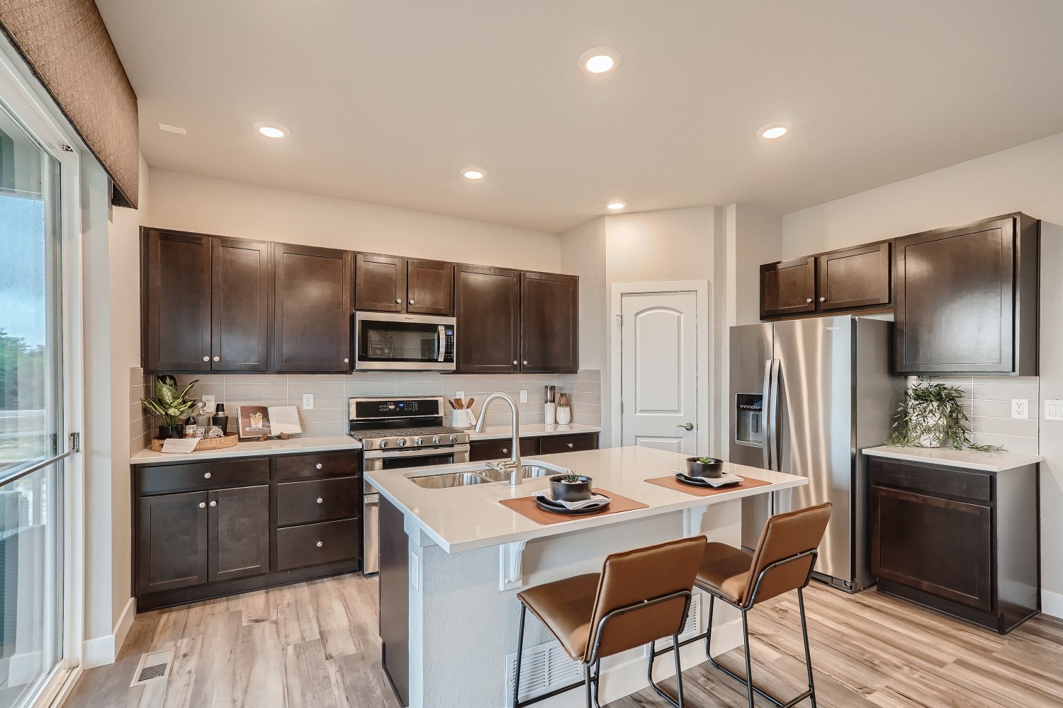 A kitchen with a table and chairs.