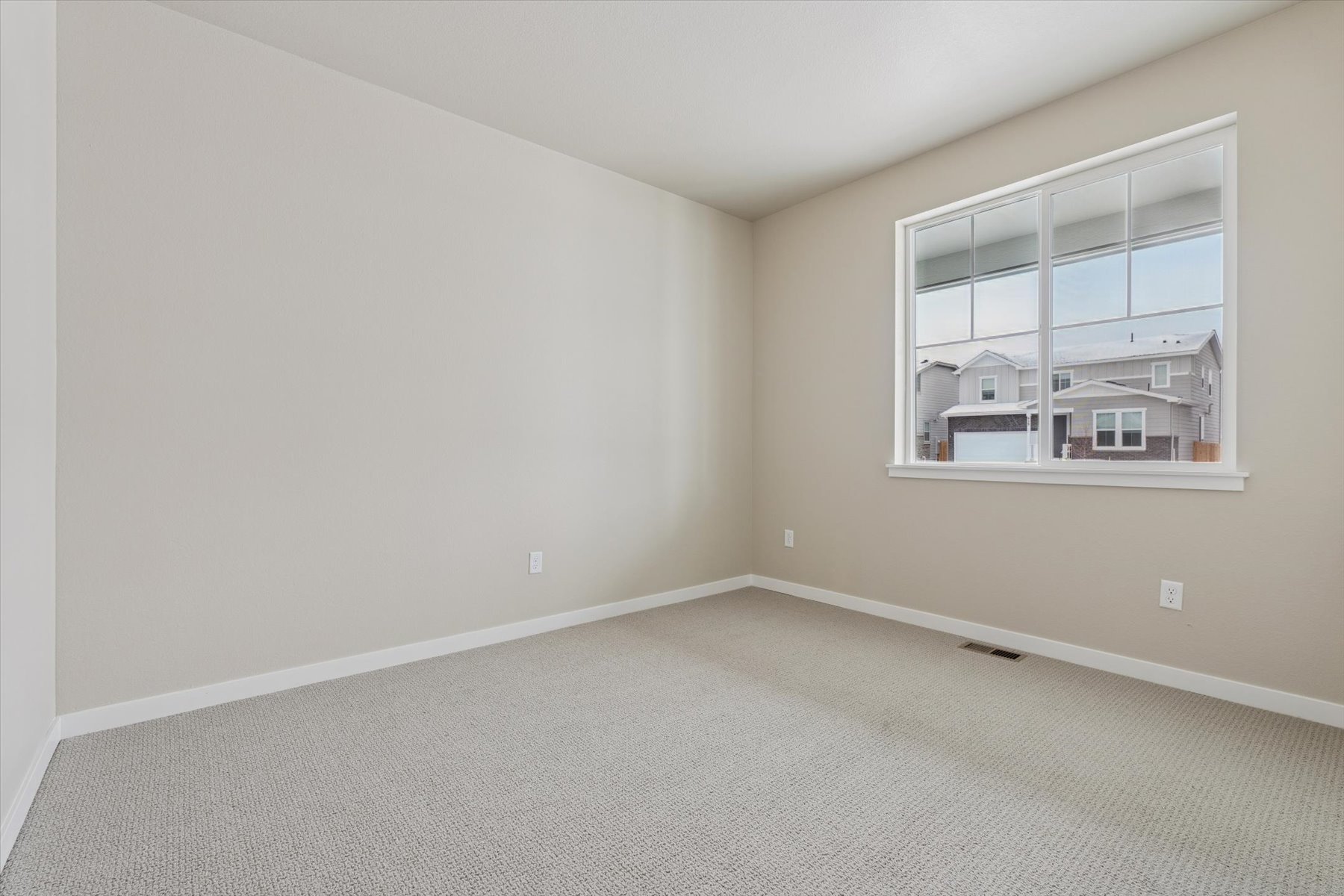 A room with a window and a carpet.