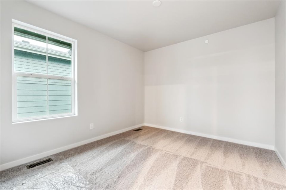 A room with a window and a rug.