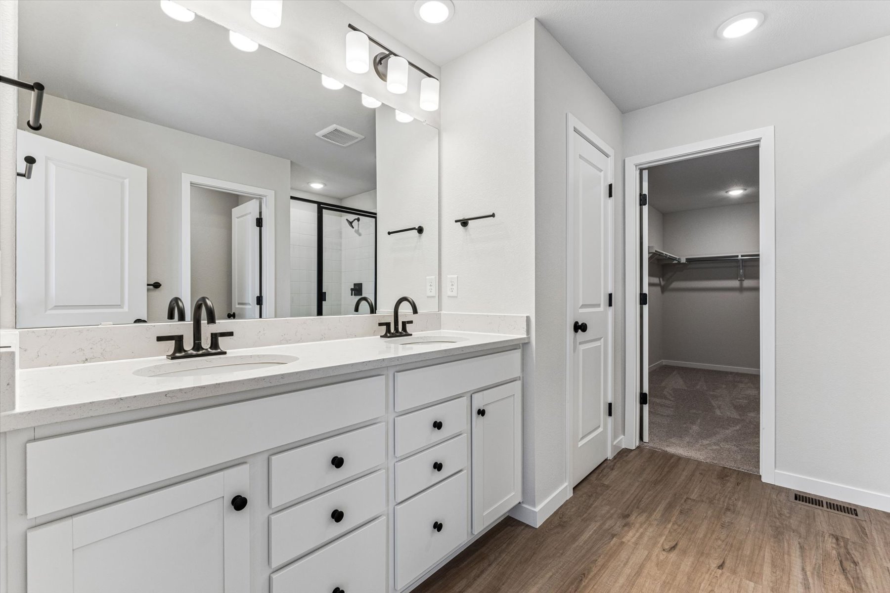 A bathroom with white cabinets.