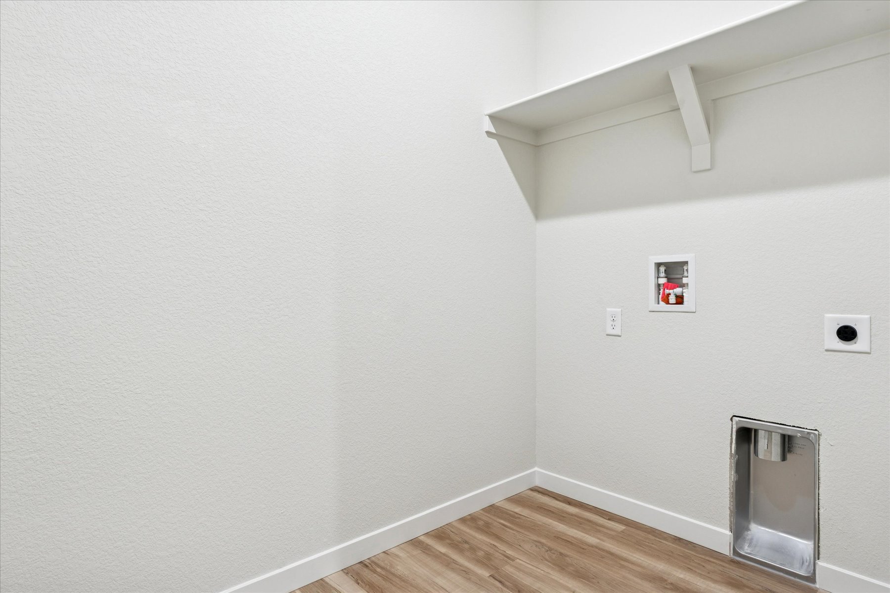 A room with a wood floor and a wood floor with a white wall.