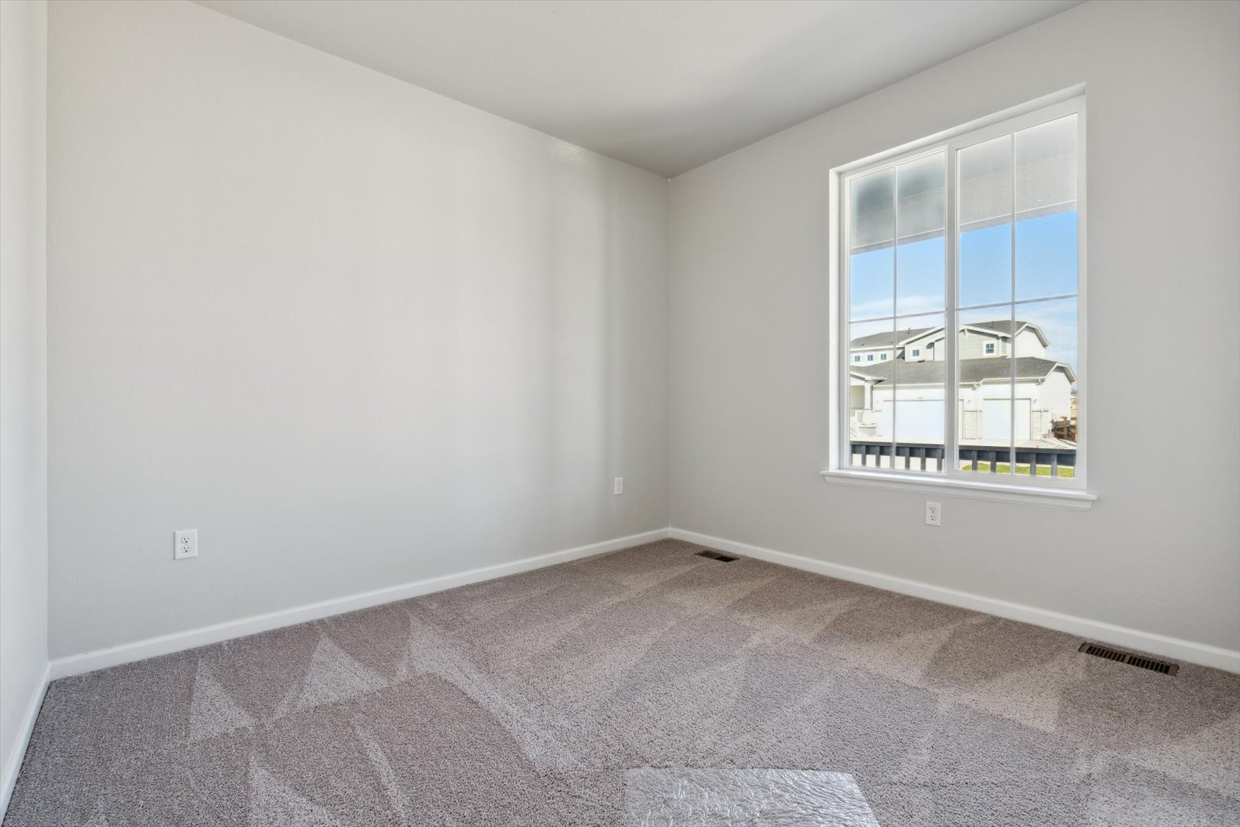 A room with a window and a rug.