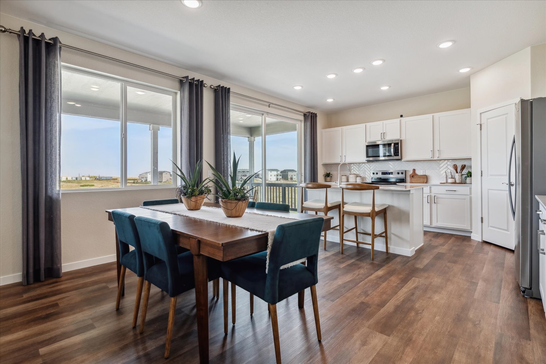 A kitchen with a dining table and chairs.