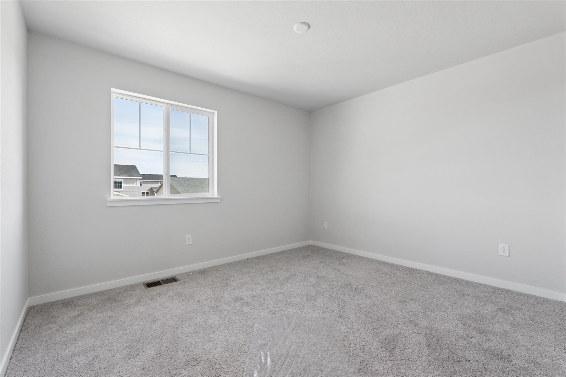 A room with a window and a carpet.