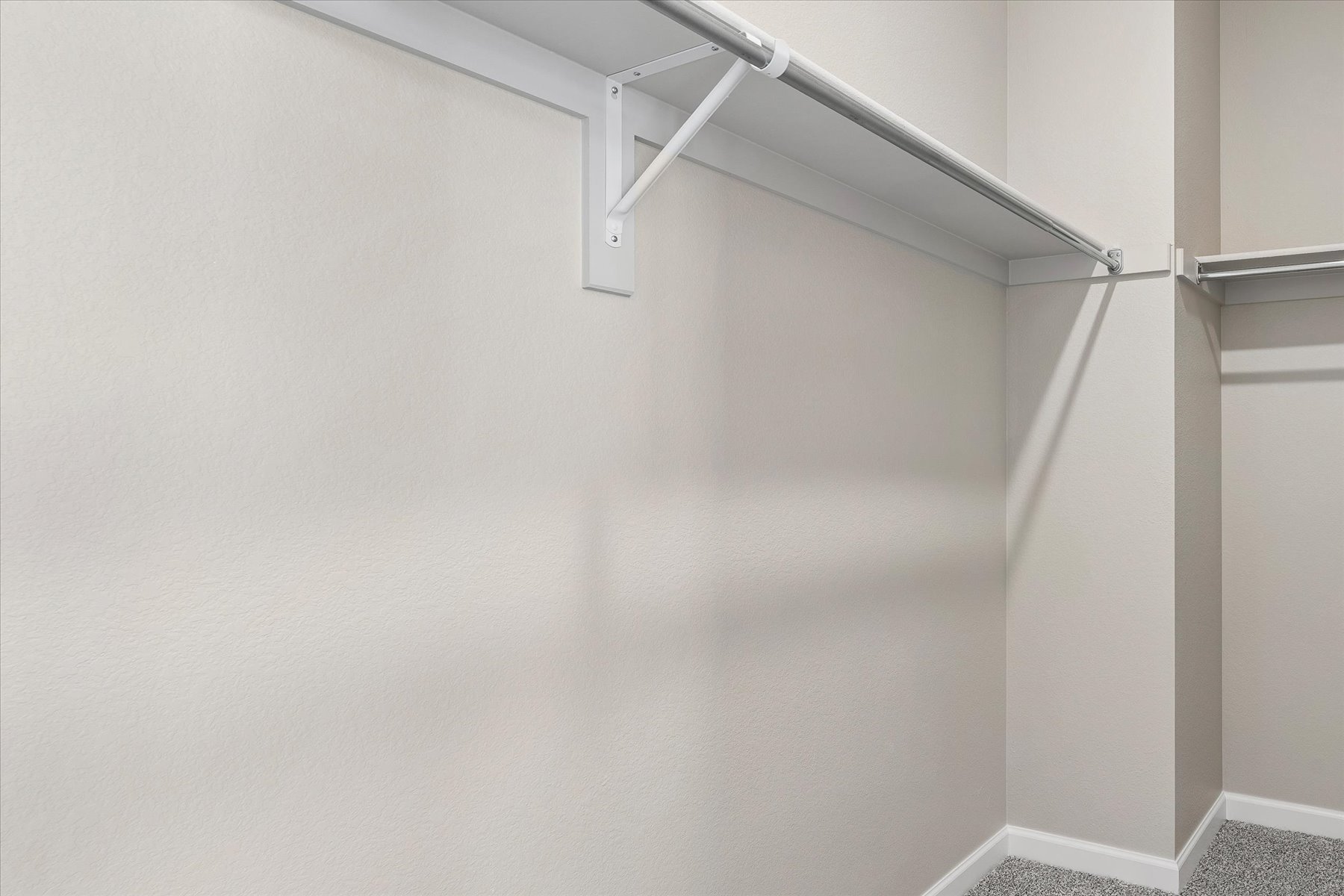 A white wall with a metal bar.