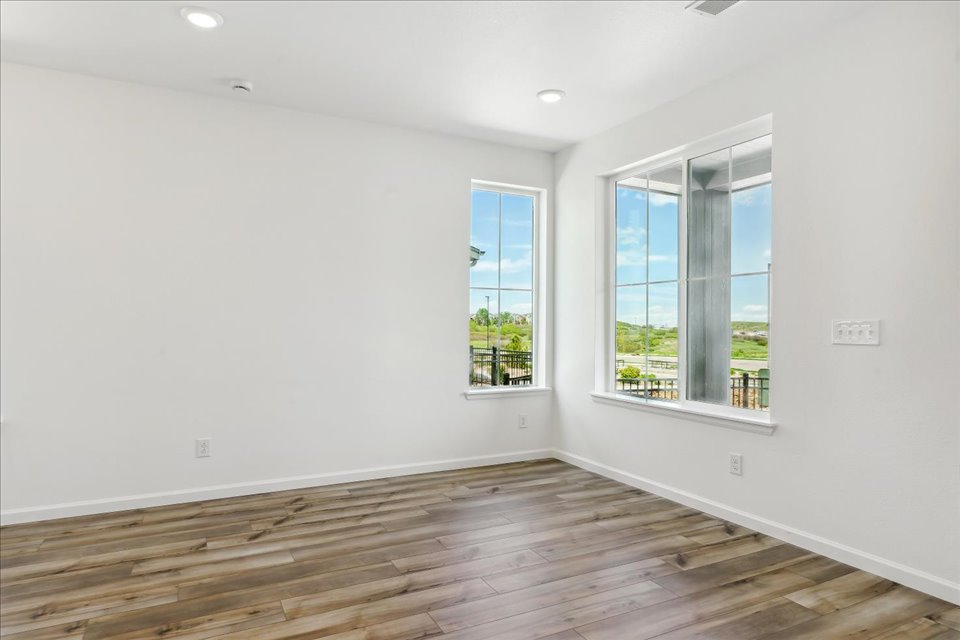A room with windows and wood floor.