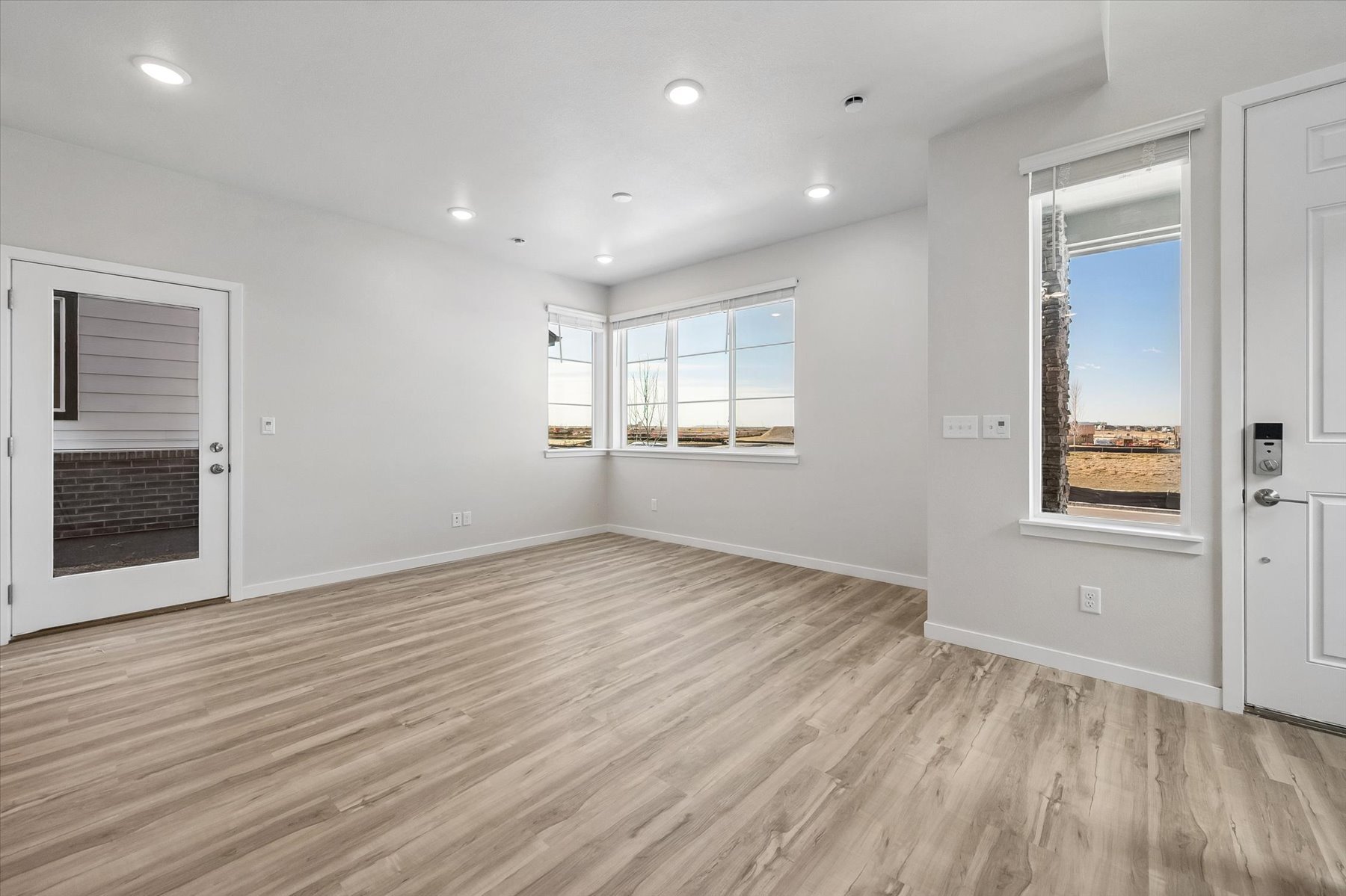 A room with a wood floor and windows.