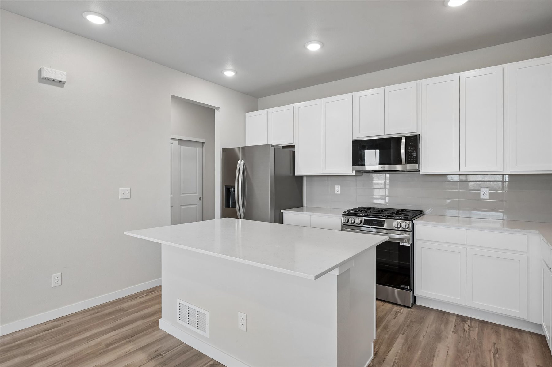 A kitchen with white cabinets.