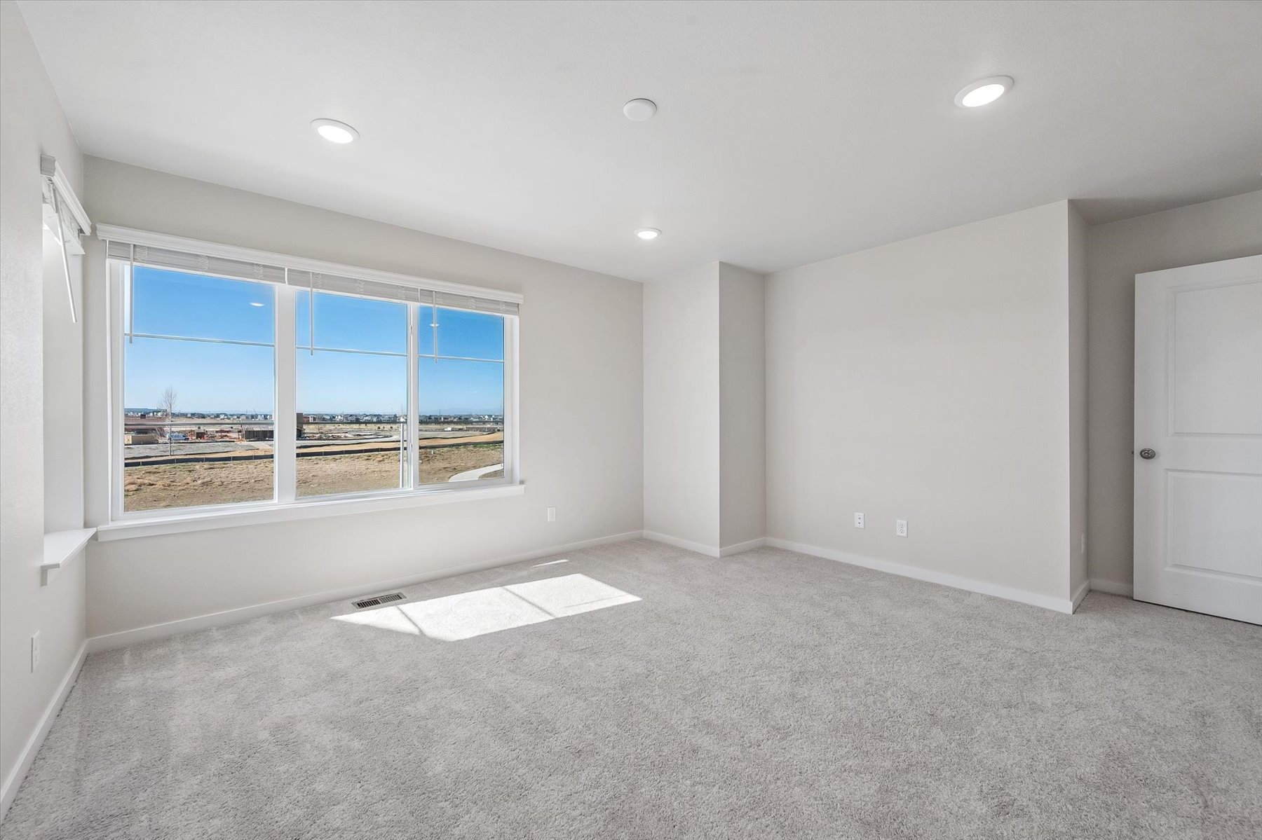 A room with a window and a rug in it.