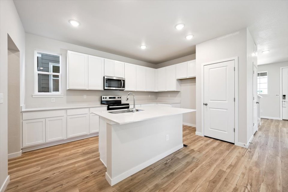 A kitchen with white cabinets.