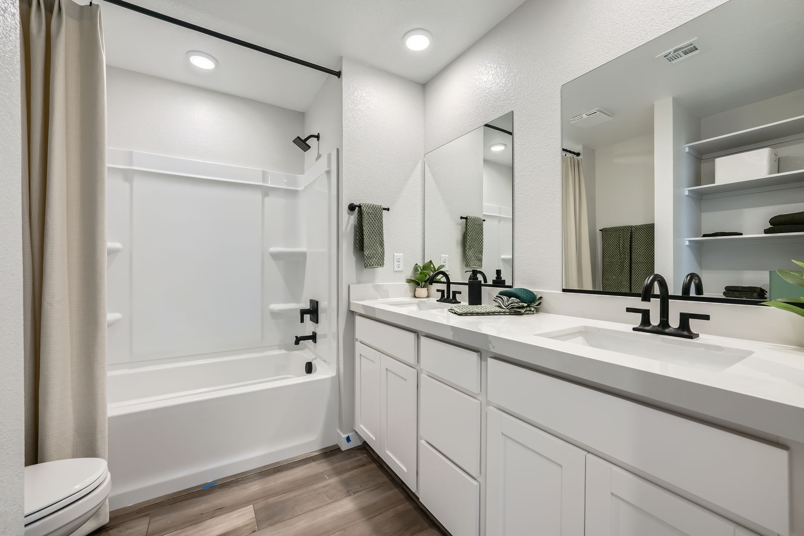 A bathroom with a tub sink and a toilet.
