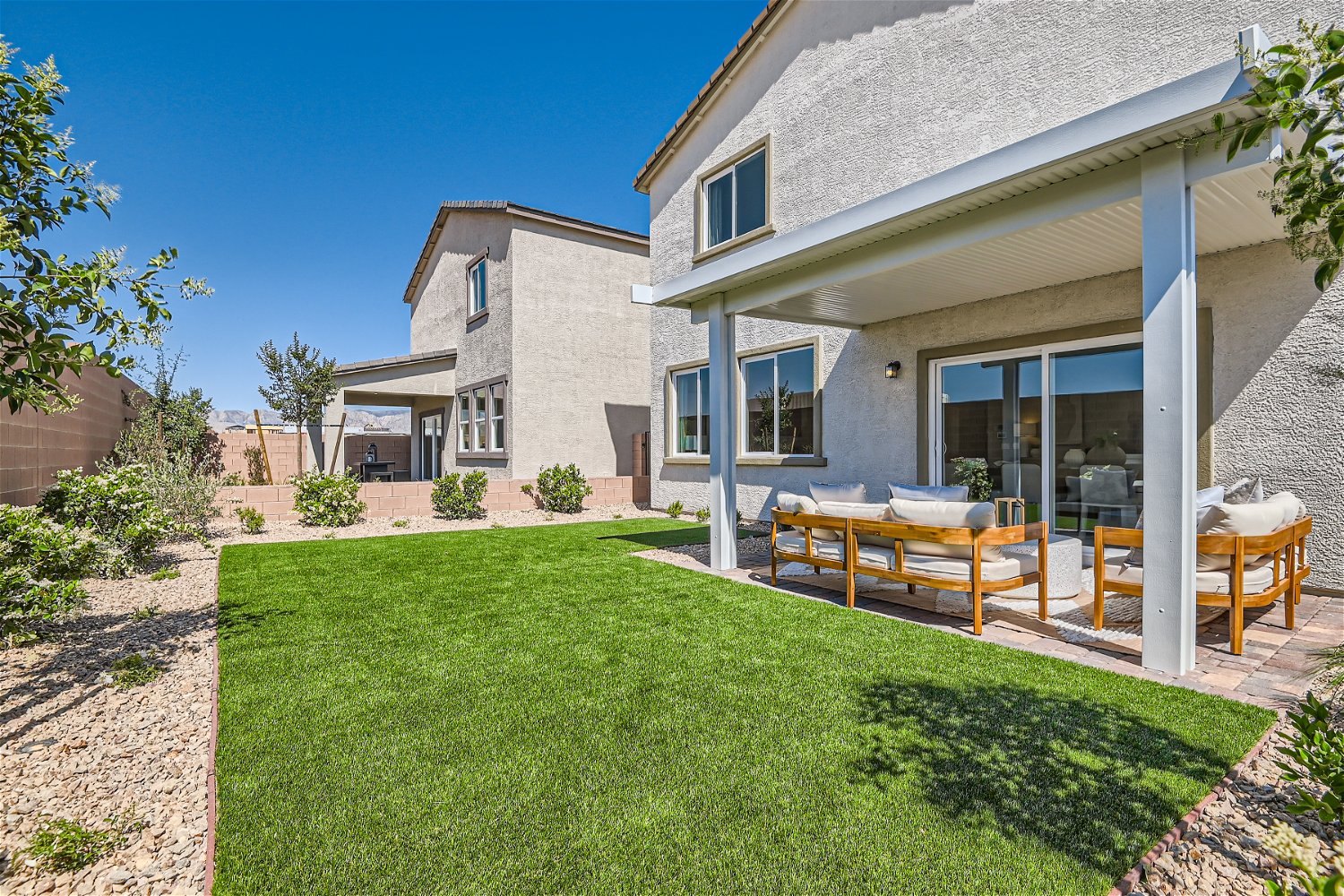 A house with a patio and a table and chairs in the front.
