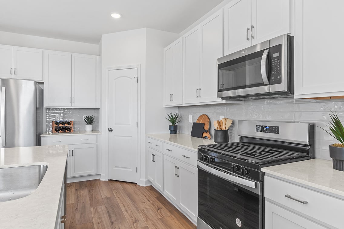 A kitchen with white cabinets.