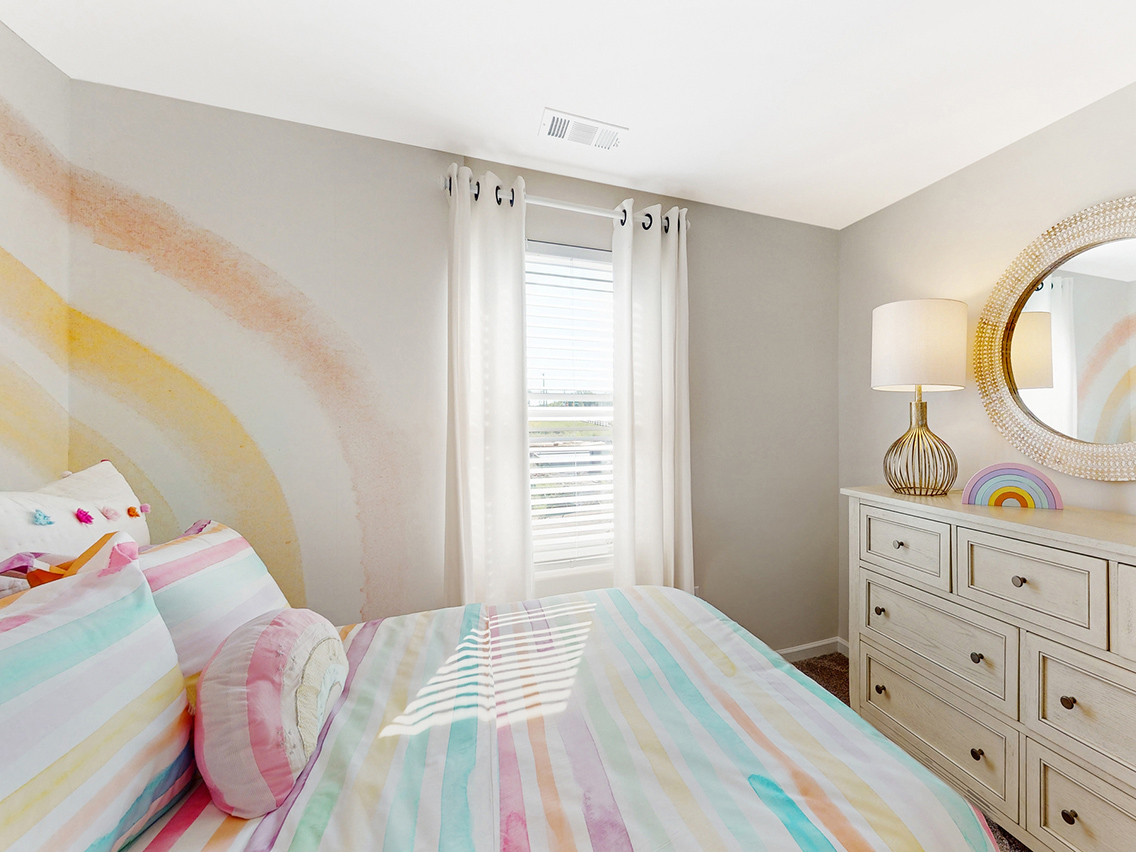 A bedroom with a bed and a mirror.