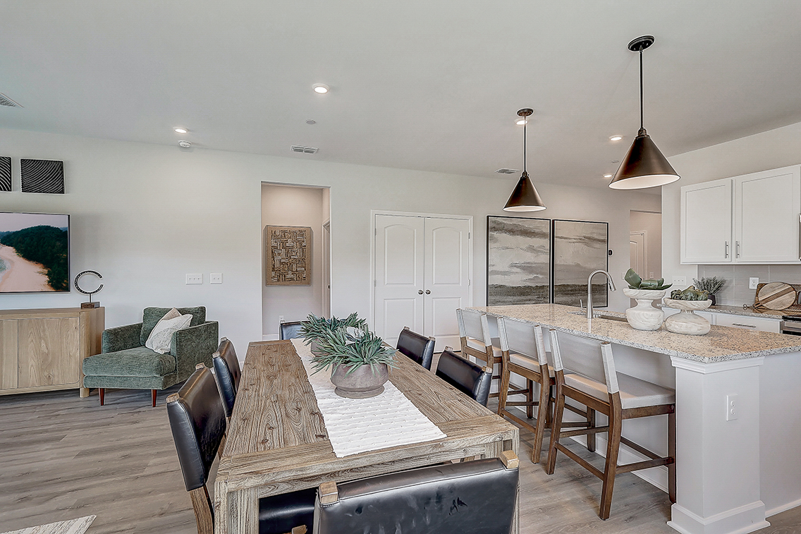 A kitchen with a dining table and chairs.
