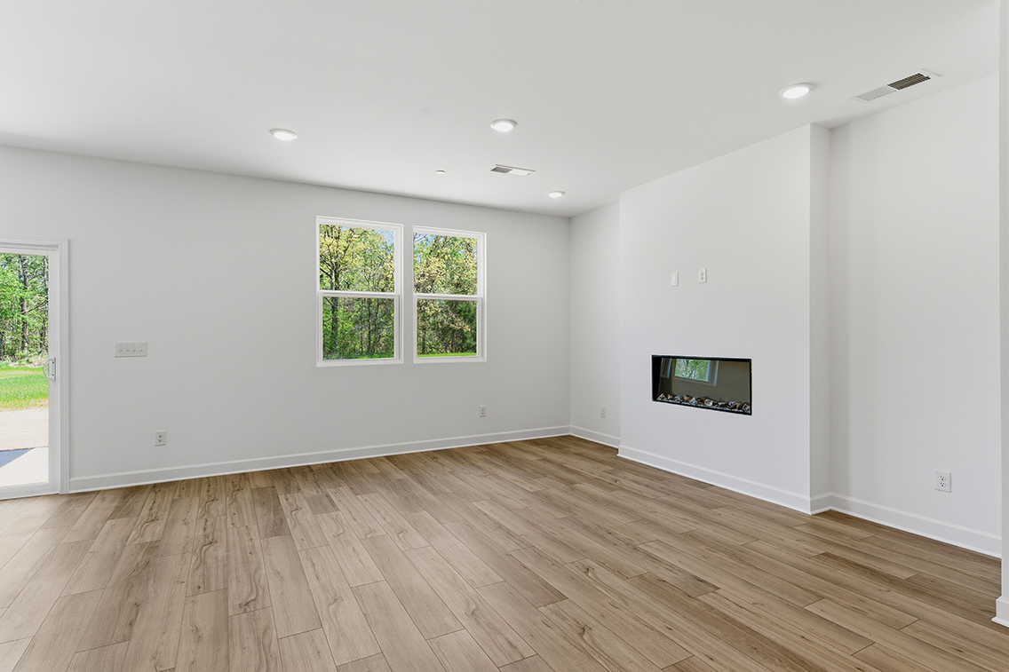 A room with a tv and a wood floor.