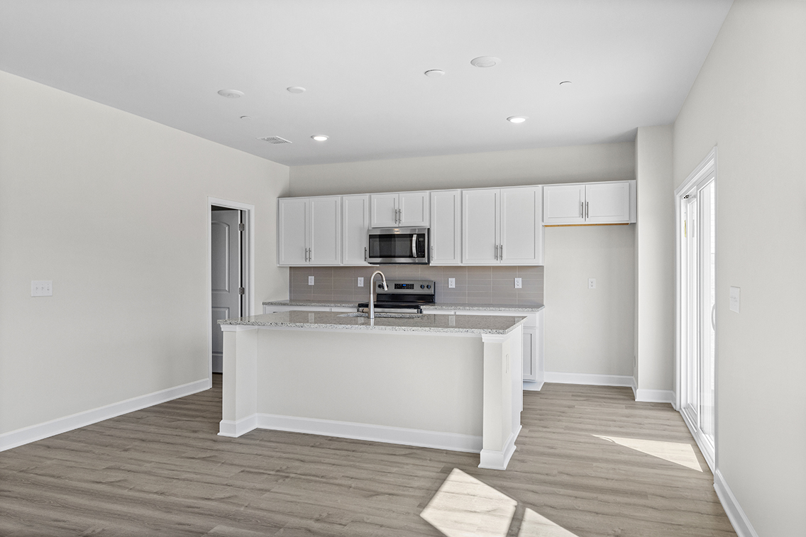 A kitchen with white cabinets.