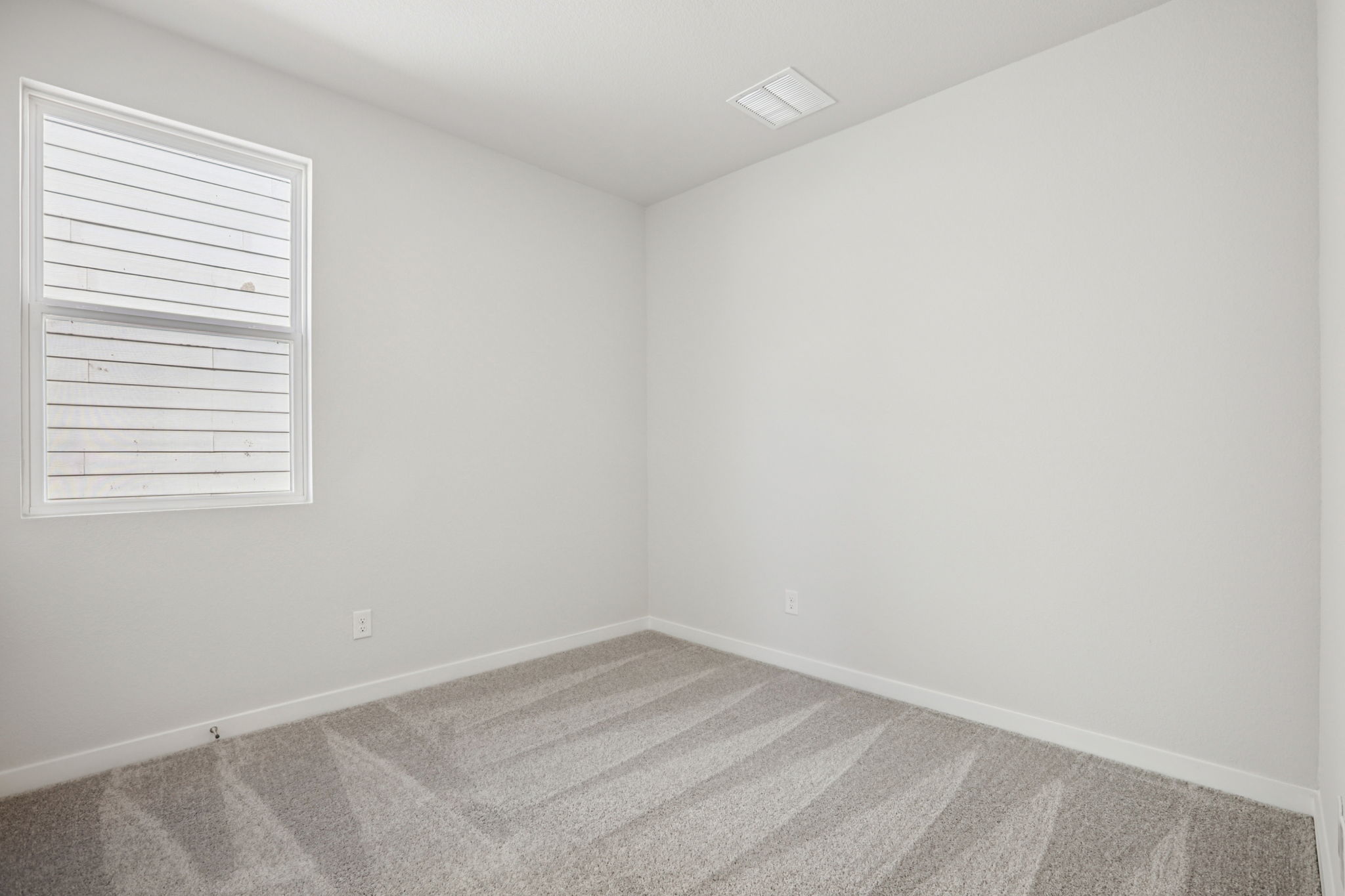 A room with a rug and a window.