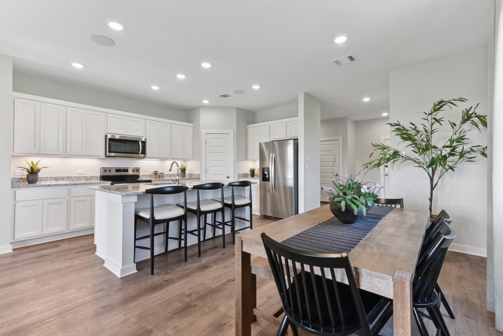 A kitchen with a dining table and chairs.