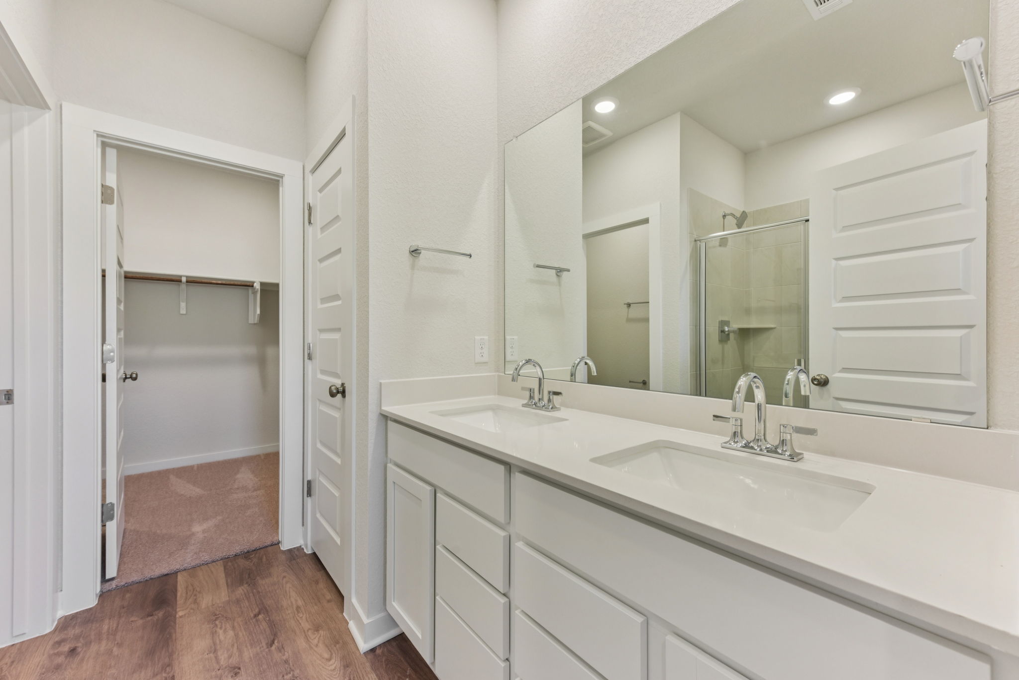 A bathroom with white cabinets.