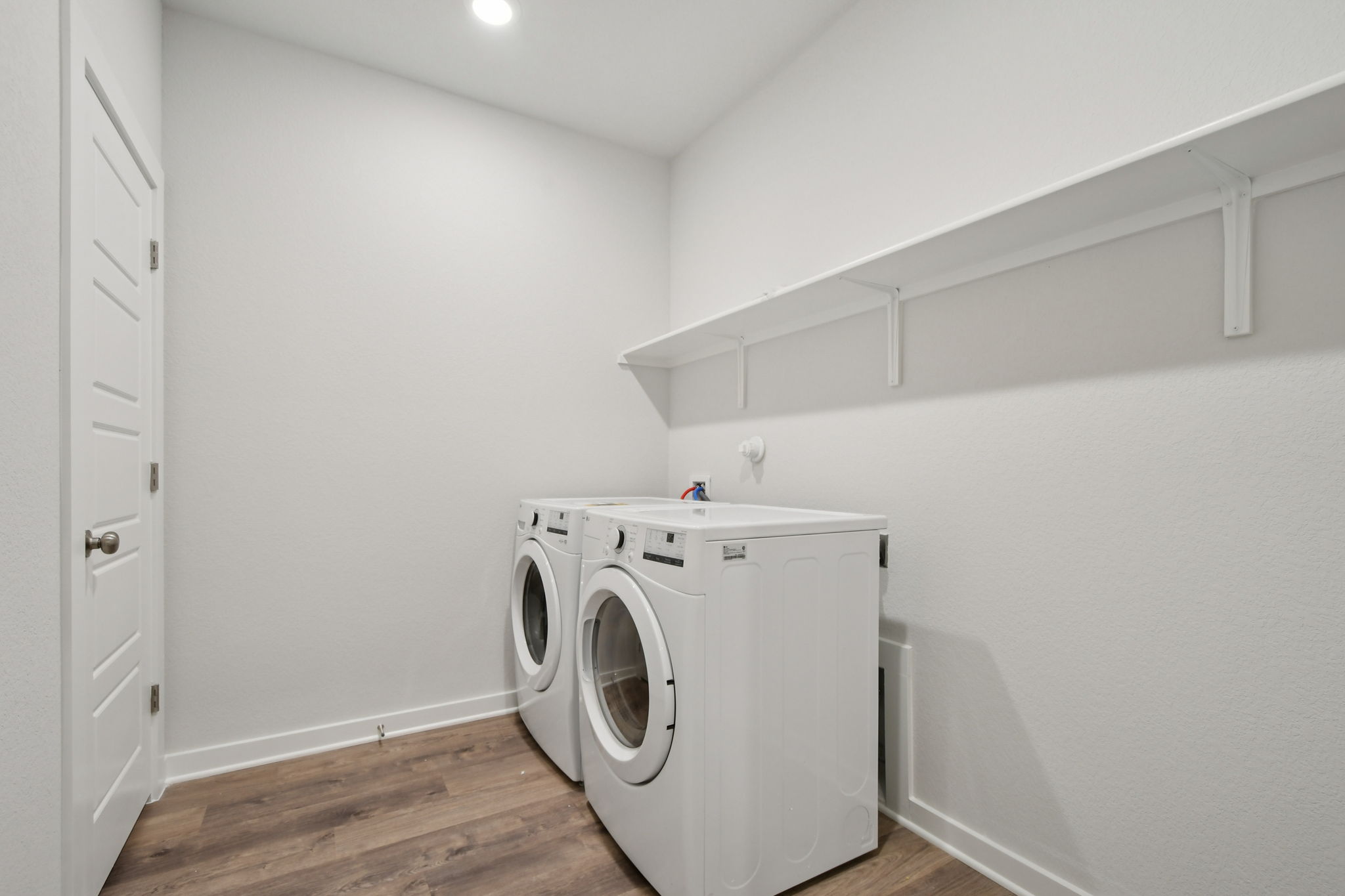 A white room with a washing machine and a white wall.
