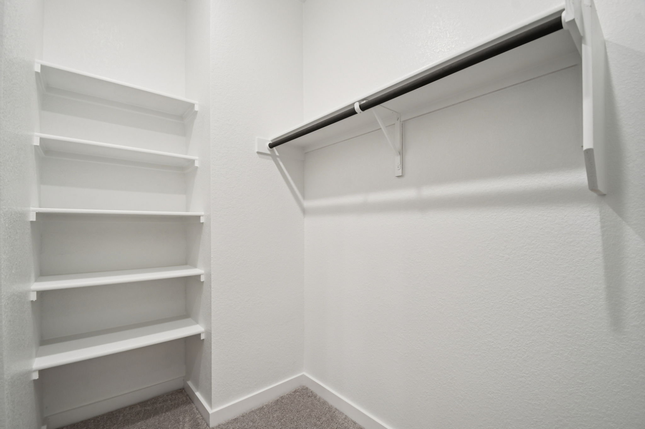 A white shelf with a metal bar.