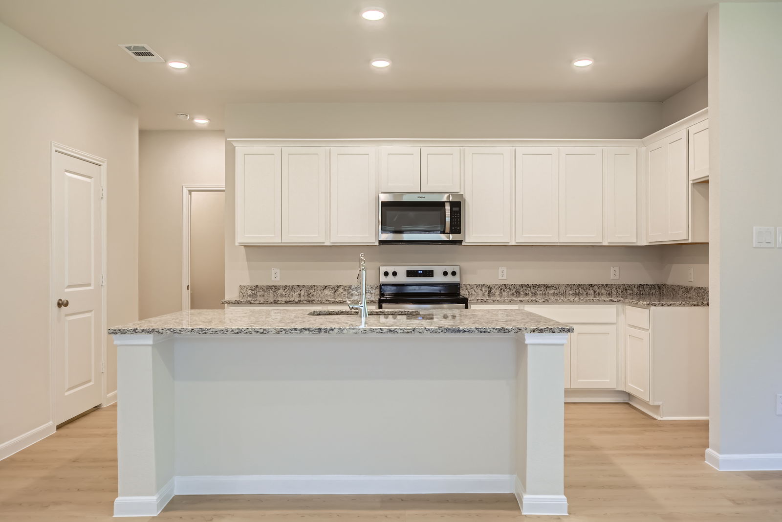 A kitchen with white cabinets.