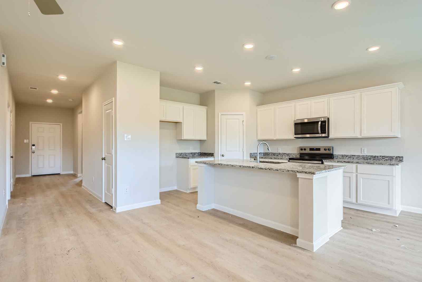 A kitchen with white cabinets.